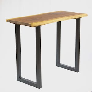 May include: A rectangular wooden console table with a natural wood top and dark metal legs. The table's top is approximately 48 inches long and 12 inches wide. The legs are a dark, matte finish, creating a modern, minimalist aesthetic.