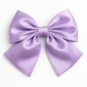 May include: A large, lavender satin bow with a classic design. The bow features a central knot and symmetrical loops and tails. The fabric has a subtle sheen, and the bow is set against a white background.