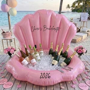 May include: A large, inflatable, pink seashell-shaped cooler filled with ice and multiple glass wine bottles. The shell features the black text "Claire's Bachelorette" on the upper section and "2026" on the lower front edge. Includes metal tongs.