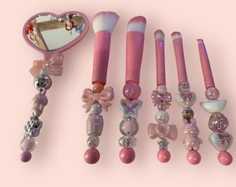 Conjunto de pincéis de maquiagem rosa bebê com detalhes em miçangas, feito à mão, e espelho.
