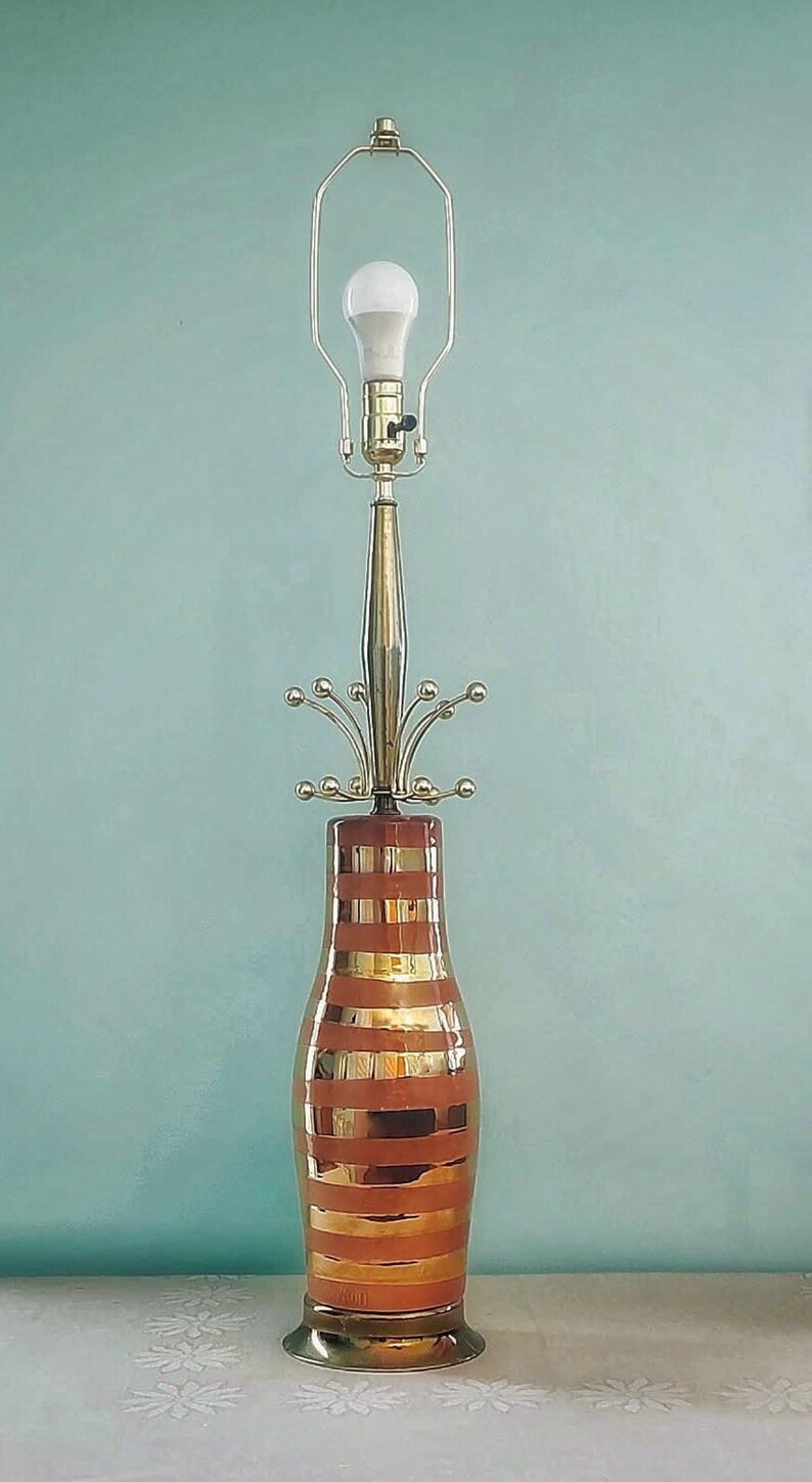 K&ouml;nnte beinhalten: Vintage Tischlampe mit braun-gold gestreiftem Sockel, Messingstiel und Gl&uuml;hbirne. Die Lampe hat ein modernes Design aus der Mitte des Jahrhunderts. Die Lampe ist etwa 71 cm hoch.