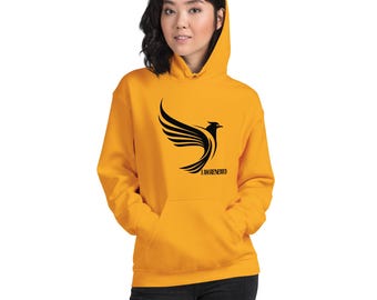 May include: Mustard yellow hoodie with a black phoenix graphic and the text "I AM RENEWED". The hoodie has a kangaroo pocket and a drawstring hood. The phoenix design features stylized wings.