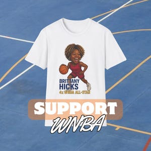 May include: White t-shirt featuring a cartoon illustration of a basketball player in a red uniform dribbling a basketball. The text "BRITTANY HICKS 4x WNBA ALL-STAR" is above the illustration. Below the illustration is the text "SUPPORT WNBA" in a white, stylized font.