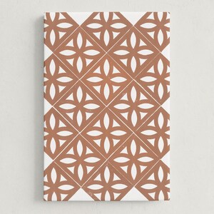 May include: A rectangular canvas print featuring a repeating geometric pattern. The design consists of terracotta-colored floral shapes set against a white background. The pattern is arranged in a grid-like formation, creating a visually appealing and symmetrical design.