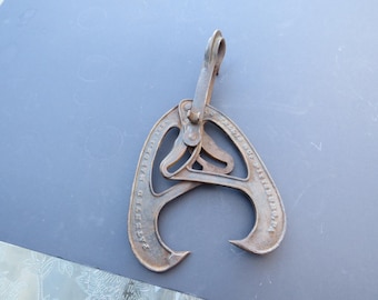 May include: An antique metal ice tong, with a curved claw design and a hinged handle. The tongs are a rusty brown color and appear to be made of cast iron. The text "PATENTED MAY 19, 1914" is visible on the side.