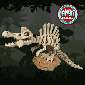 May include: A beige dinosaur skeleton model with articulated joints, displayed on a tan base. The model features a detailed skull, spine, and tail, and is set against a dark green background with a dinosaur silhouette and foliage.
