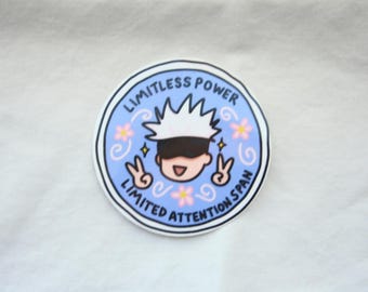 May include: A circular sticker with a light blue background featuring a cartoon character with spiky white hair and a black blindfold. The text reads LIMITLESS POWER and LIMITED ATTENTION SPAN, accompanied by small pink flowers and peace signs.
