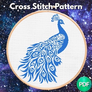 May include: A cross-stitch pattern featuring a blue peacock design within a wooden embroidery hoop. The peacock is detailed with intricate feather patterns. The text "Cross Stitch Pattern" is at the top. A PDF icon is in the bottom right corner.