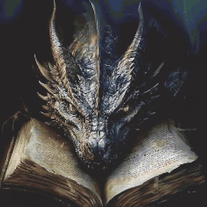 May include: A detailed cross-stitch pattern featuring a dragon head with textured scales in shades of black, gray, and gold, resting directly on top of an open, aged book with visible yellowed pages and a dark, worn leather-like cover.