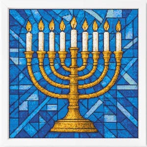 May include: A framed cross-stitch of a golden menorah with lit candles against a blue stained-glass background. The menorah has nine candle holders, each with a white candle and a yellow flame. The frame is white.