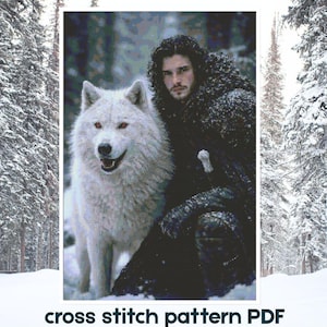 May include: A cross stitch pattern PDF featuring a digital illustration of a person with dark curly hair and a thick dark cloak standing beside a large white wolf with red eyes in a snowy forest setting with the text cross stitch pattern PDF.