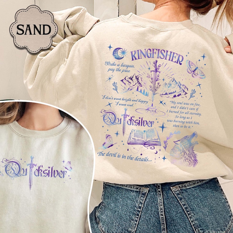 May include: Sand-colored sweatshirt with a graphic design featuring the word "Kingfisher" and the word "Quicksilver". The design includes a sword, mountains, a wolf, and text that reads "Strike a bargain, pay the price."