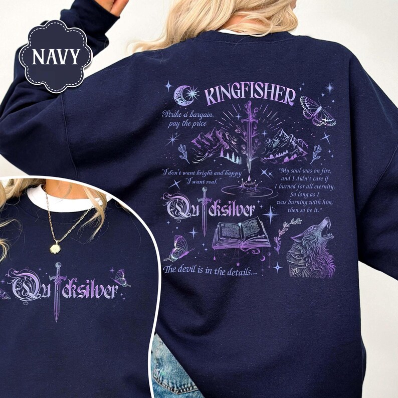 May include: Navy blue sweatshirt with a graphic design featuring the word "Kingfisher" and "Quicksilver", a sword, mountains, a wolf, and butterflies. The sweatshirt has several quotes and phrases printed on it.
