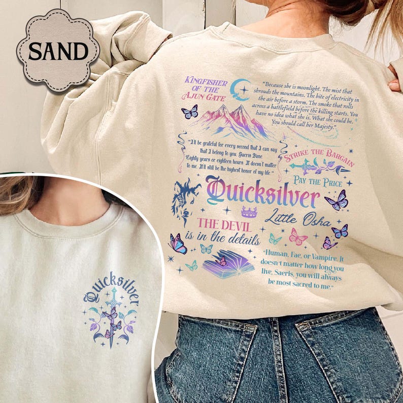 May include: Sand-coloured sweatshirt with a graphic design featuring the word "Quicksilver" in a decorative font, butterflies, and illustrations. The back of the sweatshirt has additional text and illustrations.