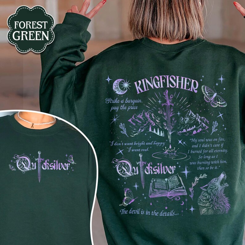 May include: Forest green sweatshirt with the word "Quicksilver" and a sword graphic on the front. The back features the word "Kingfisher" with a mountain and sword design, along with text and a wolf illustration.
