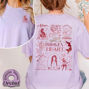 May include: Orchid Comfort Colors lilac t-shirt with a red fox graphic and text "Archer & The Fox" on the front. The back features a larger design with text and illustrations, including "Once Upon a Broken Heart".