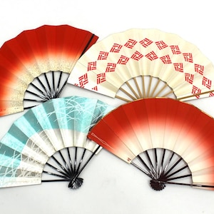 Puede incluir: Cuatro abanicos plegables decorativos en rojo, blanco y azul. Dos abanicos tienen un diseño degradado rojo, uno tiene un patrón geométrico rojo sobre fondo blanco y otro tiene un diseño azul y blanco inspirado en la naturaleza. Los abanicos están abiertos, mostrando sus intrincados diseños.