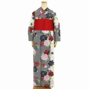 Puede incluir: Un yukata japonés, un kimono de verano informal, exhibido en un maniquí. El yukata presenta un patrón de rayas blancas y negras con acentos florales en rojo, rosa y azul marino. Un cinturón obi rojo ancho ciñe la cintura.