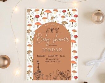 Op de afbeelding: Een uitnodiging voor een babyshower met een grillig paddenstoelthema. De uitnodiging heeft een terracotta-kleurige boog met de woorden "Baby shower" en "Honoring Jordan". De achtergrond is versierd met illustraties van paddenstoelen en bloemelementen.