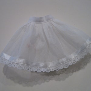May include: White tulle skirt with a satin ribbon and lace trim.