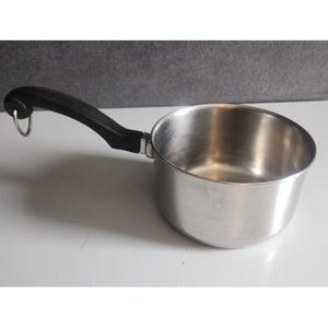 May include: A stainless steel saucepan with a black handle. The pan has a rounded body and a single handle with a loop for hanging. The handle is made of black plastic. The pan is designed for cooking.