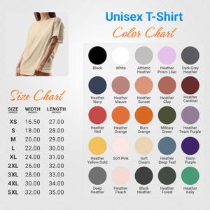 Op de afbeelding: Een beige unisex T-shirt met een kleurenkaart en maattabel. De kleurenkaart toont verschillende kleuren, waaronder zwart, wit en heidetinten. De maattabel geeft maten XS tot 5XL met afmetingen in cm.