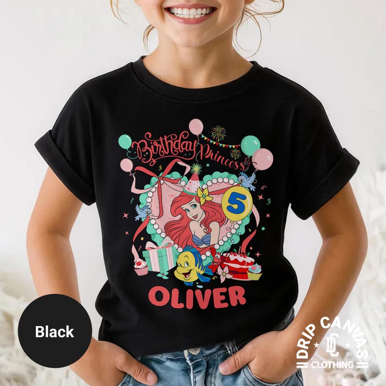 May include: Black t-shirt featuring a colorful graphic of a princess with the text "Birthday Princess" and the number 5. The design includes balloons, gifts, and the name "Oliver" in red. The shirt is from Drip Canvas Clothing.