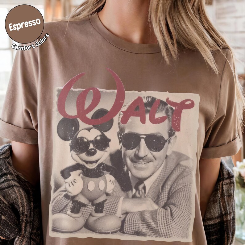 以下が含まれることがあります： エスプレッソ色のTシャツ。ミッキーマウスとウォルト・ディズニーがサングラスをかけているヴィンテージ風グラフィックと、赤いスクリプトフォントで「Walt」の文字がプリントされています。Comfort Colorsブランドのシャツです。