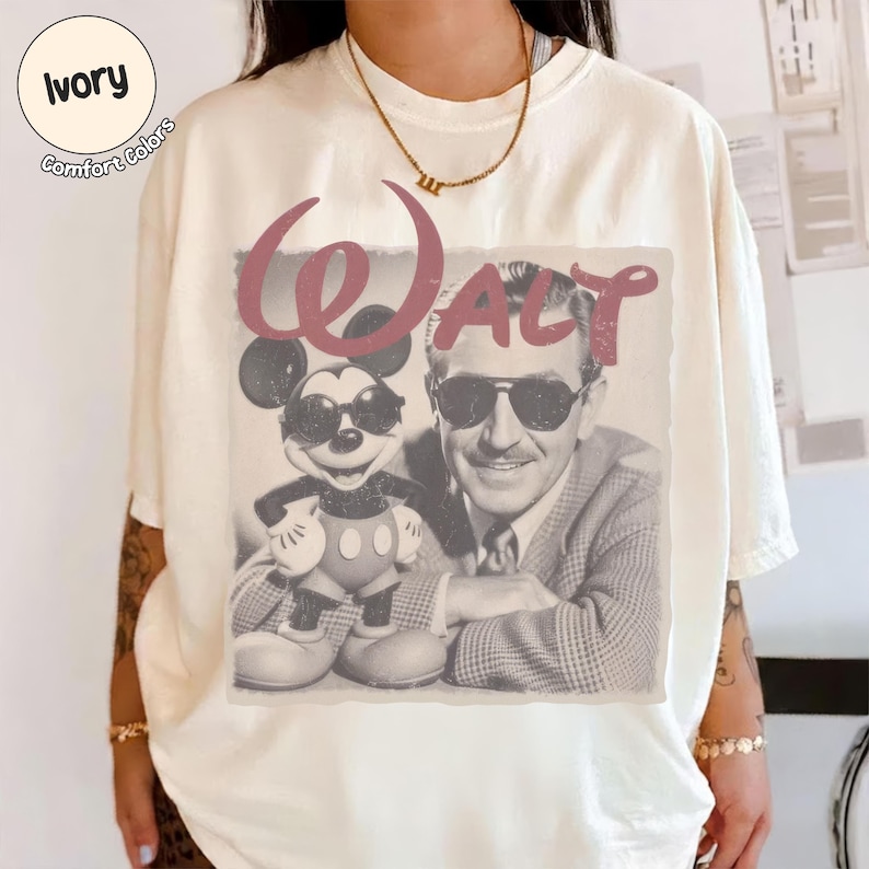 以下が含まれることがあります： アイボリー色のTシャツ。ミッキーマウスとウォルト・ディズニーがサングラスをかけているヴィンテージスタイルのグラフィックが特徴で、"Walt"の文字はバーガンディ色。シャツには"Comfort Colors"とプリントされています。