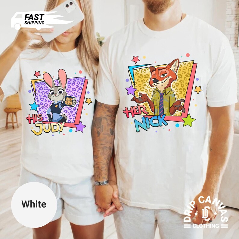 May include: White t-shirts featuring cartoon characters Judy Hopps and Nick Wilde from Zootopia. The shirts have the text "His Judy" and "Her Nick" in colorful text. The design includes stars and geometric shapes.