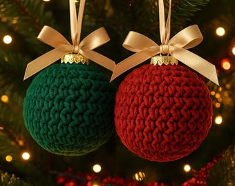 May include: Two crocheted Christmas ornaments. One is green, the other is red. Each sphere is topped with a gold-colored metal cap and a gold ribbon bow. The ornaments hang against a backdrop of a Christmas tree with twinkling lights.