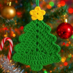 May include: A handmade green crochet Christmas tree ornament with a yellow star on top. The tree is suspended against a backdrop of a decorated Christmas tree with colorful lights and ornaments.