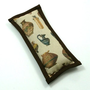 May include: A rectangular cat toy with a beige fabric featuring a pattern of ancient pottery in various colors. The toy is trimmed with a dark brown border.