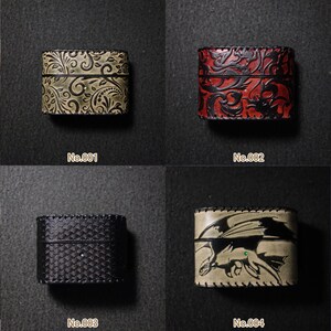May include: Four small, rectangular leather boxes with decorative designs. The boxes are in various colours, including olive green, red, black, and tan. Each box has a different embossed pattern or image, such as floral, dragon, or geometric.