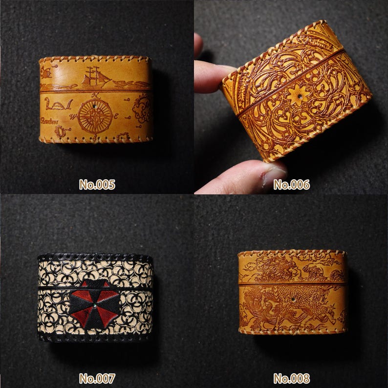 May include: Four small, rectangular leather boxes with detailed designs. One box shows a nautical map and ship, another has an ornate floral pattern, a third has a black and white pattern with a red umbrella, and the last depicts a dragon.
