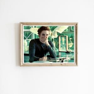 Könnte beinhalten: Gerahmter Druck mit einer Person in einem langärmeligen Hemd, die an einem Schreibtisch sitzt. Der Hintergrund umfasst ein Fenster, Kunstwerke und Skulpturen. Der Druck befindet sich in einem Holzrahmen.