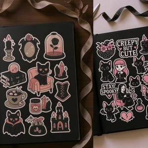 May include: Two open black journals with stickers featuring a gothic theme. Stickers include black cats, roses, bats, and the phrases "Creepy but Cute" and "Stay Spooky". The stickers are in shades of pink, black, and white.