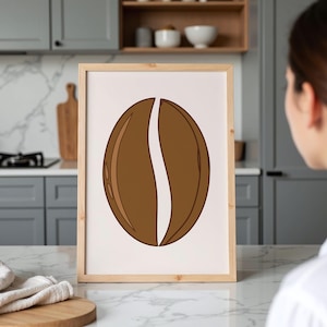 May include: A framed print showing a stylised coffee bean design. The bean is rendered in shades of brown with a white, curved line down the middle. The artwork is presented in a light wood frame, ideal for kitchen or cafe decoration.