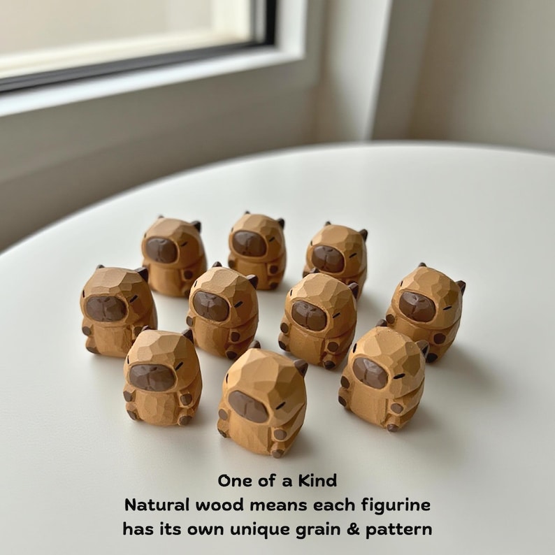 May include: A collection of ten small, carved wooden figurines. Each figurine is a light brown color with darker brown details. The text on the image reads "One of a Kind" and "Natural wood means each figurine has its own unique grain & pattern."