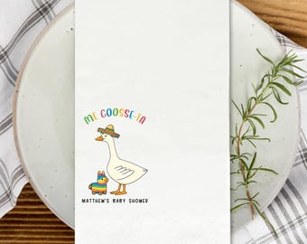 Può includere: Tovagliolo di carta bianco con un'oca dei cartoni animati con un sombrero e una colorata pignatta. Il testo "ME GOOSSE-TA" è sopra l'oca e "MATTHEW'S BABY SHOWER" sotto.