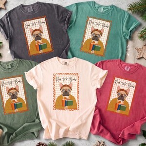 Puede incluir: Cinco camisetas de manga corta y cuello redondo en gris carbón, verde azulado, verde oliva, crema y rojo. Cada camiseta presenta un gráfico central de un bulldog francés con gafas y diadema, sosteniendo libros con el texto Read Me Books.