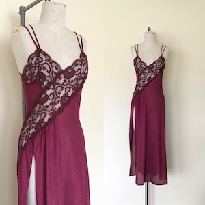 Op de afbeelding: Een bordeauxrode slipdress met een kanten overlay en een hoge split. De jurk heeft dunne bandjes en een V-hals.