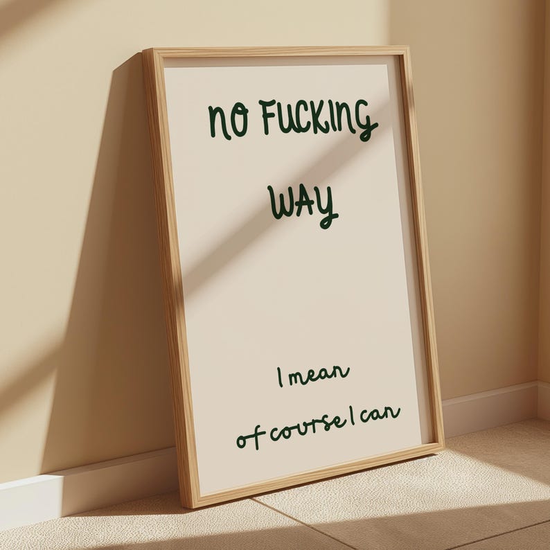 May include: A framed print with the words "no Fucking Way" in dark green script. Below, the text continues with "I mean of course I can". The frame is light brown, and the background is a cream color.