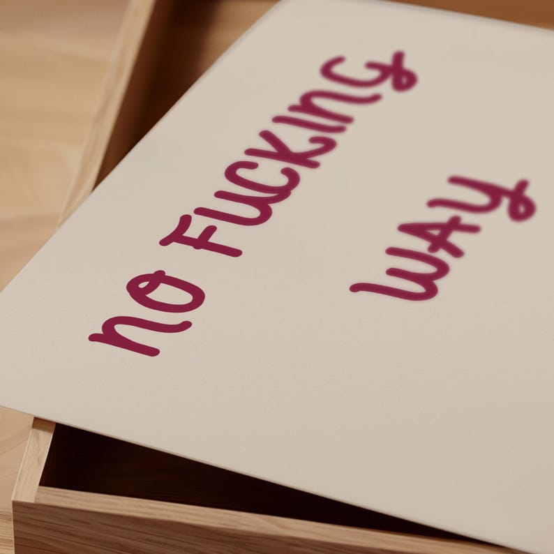 May include: A rectangular, off-white print with the words "NO FUCKING WAY" in a handwritten, dark pink font. The print is inside a wooden box, partially visible in the image.