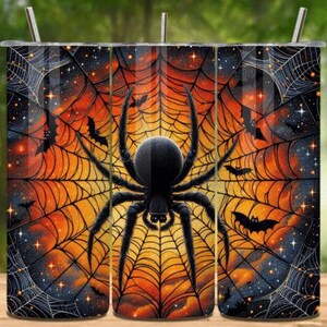 May include: A cylindrical tumbler featuring a vibrant orange and black spiderweb pattern. A large, detailed black spider is centred on the front, surrounded by silhouettes of flying bats and small sparkling stars against a dark, gradient background.