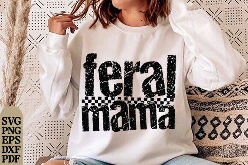May include: White sweatshirt with the text "feral mama" in a distressed black font. The text is above a black and white checkered pattern. The sweatshirt has long sleeves.