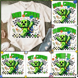 May include: Cream-colored t-shirt with a green and black graphic of a Minecraft-style character, with the words "3RD GRADE" in green. The design includes checkered flags, a globe, and school-themed elements. Additional shirts with different grade levels are also shown.