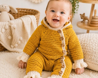 May include: A mustard yellow crocheted baby romper with a hood, featuring a side-button closure with light beige wooden buttons and matching light beige ribbed cuffs at the wrists and ankles with a delicate scalloped edge detail.