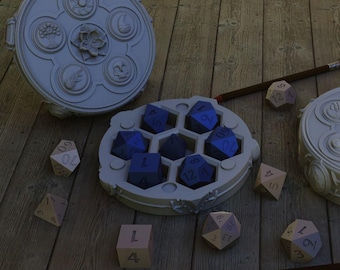 Könnte beinhalten: Eine Sammlung von Würfelspielwürfeln und Aufbewahrungsbehältern. Die Würfel haben verschiedene Formen und Farben, darunter Blau und Beige. Die Behälter sind rund mit dekorativen Designs. Bleistifte mit roten Radiergummis sind ebenfalls vorhanden, alles auf einer Holzoberfläche.
