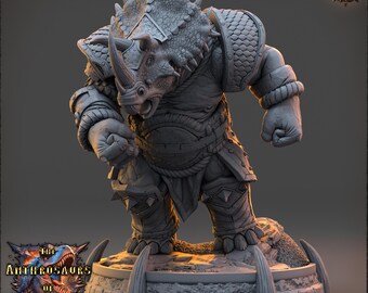 Pode incluir: Figura em miniatura cinzenta detalhada de uma criatura semelhante a um rinoceronte em armadura, em pé sobre uma plataforma de pedra. A figura tem um chifre grande, protuberâncias pontiagudas e detalhes intrincados de armadura. A base tem o texto "The Anthrosaur of Trito" e o logotipo "Daybreak Miniatures".